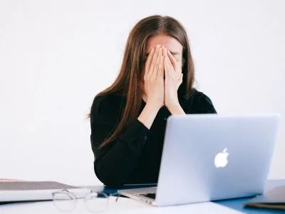 Une femme qui se tient la tête dans les mains devant son site wordpress cassé
